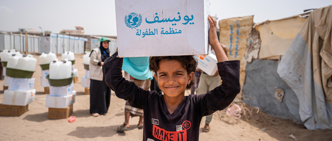 A boy from Yemen receives a box with emergency supply.